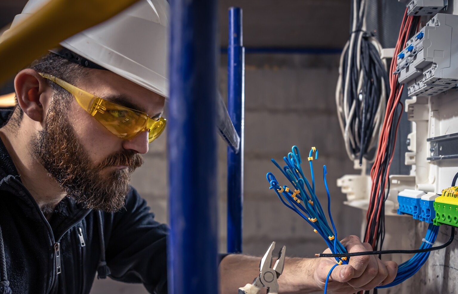 male-electrician-works-switchboard-with-electrical-connecting-cable male-electrician-works-switchboard-with-electrical-connecting-cable